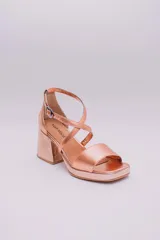 Sandalias de cuero color cobre con plataforma y taco cuadrado. Tiras cruzadas sobre el empeine y pulsera con hebilla al tobillo.