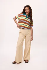 Pantalón recto color amarillo con rayas verticales blancas.