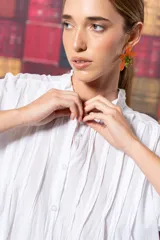 Camisa blanca de algodón con corte amplio, tablitas en la parte delantera y volados en el cuello.