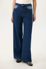 Pantalón de jean azul con corte acampanado y diseño de bloques de color en diferentes tonos de azul.