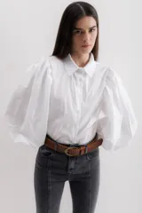 Camisa color beige de algodón con mangas abullonadas y cierre con botones.
