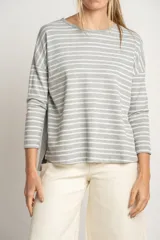 Sweater oversize gris con rayas horizontales blancas, de tejido suave y mangas largas.