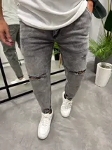Jean gris con efecto lavado, corte slouchy, tiro medio y roturas en las rodillas.