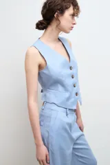 Chaleco sastre color amarillo mostaza, confeccionado en lino con forro de algodón y cierre frontal con botones.