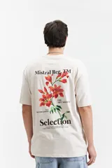 Remera color crudo de corte amplio, con mangas cortas y estampado en la espalda con flores rojas y texto en negro.