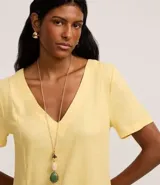 Vestido t-shirt color amarillo, confeccionado en viscolino, con escote en V y mangas cortas. Posee bolsillos laterales.