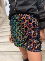 Minifalda negra con lentejuelas multicolores y diseño floral.