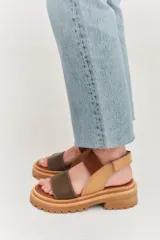 Sandalias con tiras en color beige y suela gruesa, diseñadas para brindar comodidad.