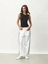 Pantalón blanco de corte ancho con una fina línea negra vertical en los laterales.