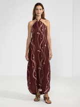 Vestido largo marrón con estampado de cadenas y flores rosadas, escote halter con cordón ajustable y insignia Polonio removible.