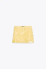 Minifalda color amarillo pálido cubierta de lentejuelas.