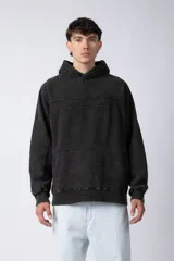 Buzo canguro negro de frisa gruesa de algodón con capucha y calce oversize.