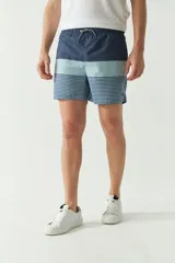 Short de baño con cintura elástica y cordón ajustable, con dos bolsillos laterales y uno trasero. Diseño a rayas horizontales en tonos de azul.