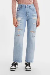 Pantalón de jean celeste claro, de corte recto, tiro alto y largo hasta el tobillo. Presenta roturas grandes en ambas piernas y terminación desflecada.