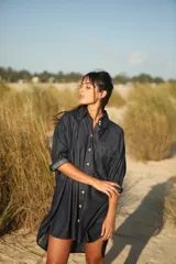 Camisa corta de jean celeste, de corte amplio, con cuello camisero, mangas largas abullonadas con puños elastizados, cierre frontal con botones y bolsillo plaqué en el pecho.