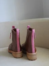 Botas cortas de cuero color marrón con cierre de cremallera lateral y detalle de ribete rosa.