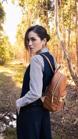 Mochila negra de nylon con bolsillo frontal con cierre y detalles en símil cuero. Tiene asa de mano, correas regulables y bolsillo trasero vertical con cierre. En el interior tiene dos bolsillos con cierre y uno abierto con división.