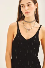 Musculosa negra de tejido rib con lentejuelas bordadas a tono, de calce al cuerpo y escote en V.