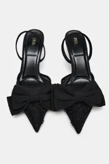 Zapato destalonado con tacón fino, capellada de mesh bordado, detalle de lazo en la parte delantera y tira trasera ajustable.