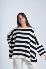Sweater oversize de punto color crema con rayas horizontales negras, cuello redondo y mangas largas.