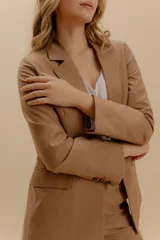 Blazer blanco de corte entallado, con solapas, cierre de un botón y bolsillos con tapa. Confeccionado en tela de sastrería noble.