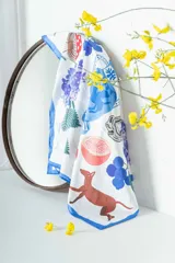 Pañuelo cuadrado de seda premium con estampado de motivos naturales y animales en tonos azul, marrón, rojo y verde.