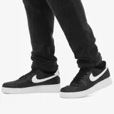 Zapatillas Nike Air Force 1 '07 de cuero negro con detalles en blanco, suela de goma blanca y perforaciones en la puntera.