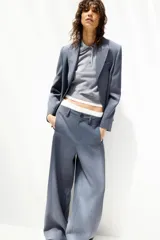 Pantalón de vestir celeste con corte palazzo, tiro alto, bolsillos laterales y cierre frontal con cremallera y botón.
