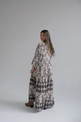 Vestido largo con estampado geométrico en blanco y negro, con mangas 3/4 y cuello en V.