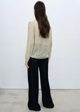 Blusa de gasa negra con estampado de margaritas blancas, cuello pico con lazo y cierre de botones frontal.