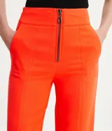 Conjunto sastrero color naranja, compuesto por un blazer entallado con solapas de muesca, cierre con lazo y pantalón de vestir recto de tiro alto.