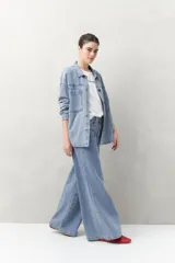 Pantalón de jean negro de calce ultra wide leg, tiro alto y silueta amplia desde la cadera hasta el bajo. Diseño clásico de cinco bolsillos y cierre con botón metálico y cremallera.