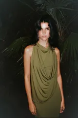 Vestido largo color verde oliva, de tejido de punto con tul, cuello redondo y sin mangas. Presenta un drapeado en la parte superior y cierre lateral con cremallera oculta.