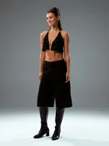 Top negro con lentejuelas, corte halter y espalda descubierta.