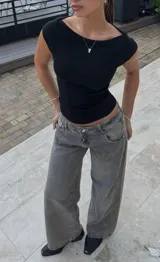 Pantalón de jean ancho (wide leg) color gris oscuro lavado, tiro alto, con efecto desgastado.