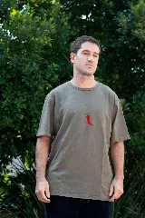 Remera color beige de manga corta con estampado de un ají rojo.