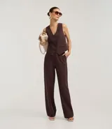 Pantalón de vestir de corte recto, color marrón oscuro con finas rayas verticales en tono más claro. Presenta un calce sastrero y bolsillos laterales.