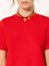 Remera blanca de jersey pesado con escote redondo, mangas cortas y bordado de un ají rojo en el frente.