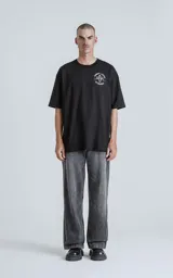 Remera negra de algodón con cuello redondo y calce oversize. Estampado en la espalda con diseño de la carta del tarot 'El Diablo', con figura femenina con cráneo de carnero sobre una pila de cráneos.