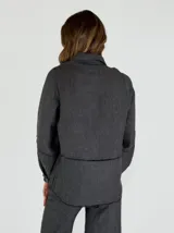 Chaqueta azul de lino con cuello camisero, cierre frontal con botones, mangas largas con puños abotonados, dos bolsillos de parche en el pecho y bajo con terminación desflecada.