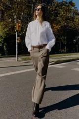 Pantalón cargo de tiro alto color marrón topo, con pierna ancha y holgada que se estrecha hacia el tobillo. Presenta bolsillos delanteros, bolsillo de plastrón lateral y falso bolsillo de vivo en la espalda.