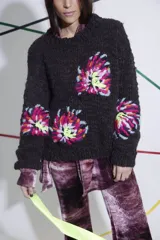 Sweater tejido y bordado a mano en lana merino, color marrón oscuro, con cuello redondo y puños ajustados. Presenta bordados florales multicolores en el frente y las mangas.