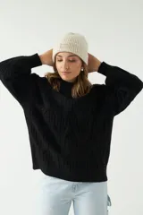 Sweater negro de punto grueso con diseño de trenzas.