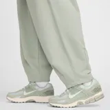 Pantalón largo Nike Club Ft Oversized de hombre, color verde claro, con cintura elástica y logo pequeño bordado en blanco.