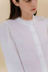 Camisa negra de lino con cuello mao, mangas abullonadas con elástico en los puños y botones forrados en la misma tela.