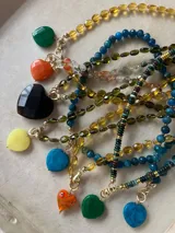 Collar de cuentas de colores con dijes de corazón de diferentes piedras.