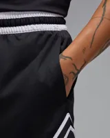 Short deportivo negro con cintura elástica y cordón de ajuste. Presenta ribetes blancos en la cintura y en los bordes de las piernas, con un diseño angular en los laterales.