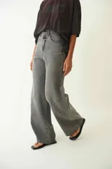 Pantalón jean gris de tiro medio, corte amplio y pierna recta.