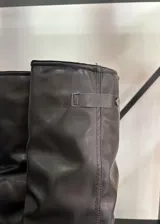 Botas de caña alta color marrón con hebilla lateral.