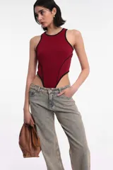 Body color burdeos con cuello redondo y ribete negro.